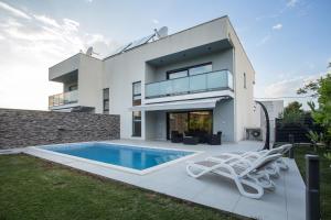 a house with a swimming pool in front of it at Villa Tesa 2 in Okrug Donji