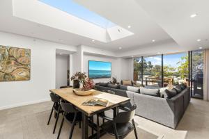 a living room with a table and a couch at Oceanview Penthouse by Experience Jervis Bay in Huskisson