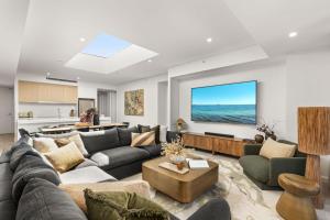 a living room with a couch and a tv at Oceanview Penthouse by Experience Jervis Bay in Huskisson