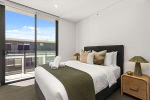 a bedroom with a large bed and a large window at Oceanview Penthouse by Experience Jervis Bay in Huskisson