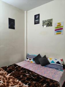a bed in a room with pictures on the wall at little comfortable cozy Room in Chandīgarh