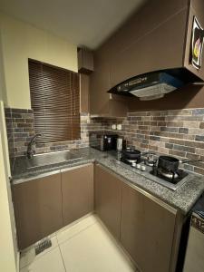 a kitchen with a sink and a stove top oven at SkyLuxe Studio 2 with rooftop Pool & Self Check In in Islamabad