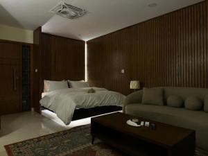 a bedroom with a bed and a couch at SkyLuxe Studio 2 with rooftop Pool & Self Check In in Islamabad +28 photos