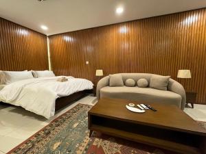 a bedroom with a bed and a couch and a coffee table at SkyLuxe Studio 2 with rooftop Pool & Self Check In in Islamabad
