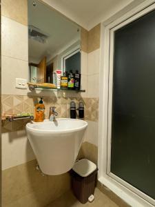 a bathroom with a sink and a mirror at SkyLuxe Studio 2 with rooftop Pool & Self Check In in Islamabad