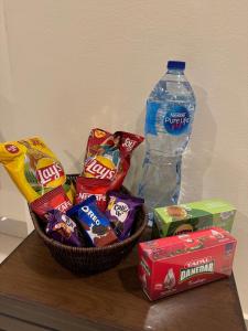a basket of chips and a bottle of water on a table at SkyLuxe Studio 2 with rooftop Pool & Self Check In in Islamabad
