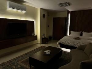 a hotel room with a bed and a tv at SkyLuxe Studio 2 with rooftop Pool & Self Check In in Islamabad