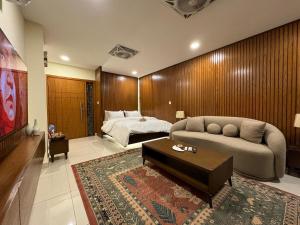a living room with a couch and a bed at SkyLuxe Studio 2 with rooftop Pool & Self Check In in Islamabad
