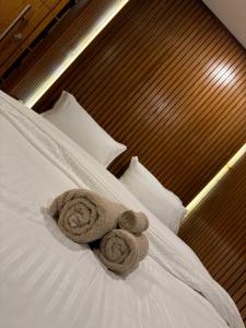 two towels sitting on top of a bed at SkyLuxe Studio 2 with rooftop Pool & Self Check In in Islamabad
