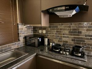 a kitchen counter with a stove and a sink at SkyLuxe Studio 2 with rooftop Pool & Self Check In in Islamabad