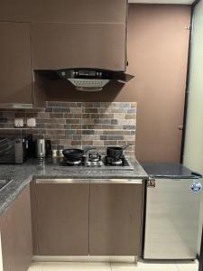 a kitchen with a stove with pots and pans on it at SkyLuxe Studio 2 with rooftop Pool & Self Check In in Islamabad