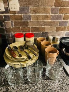 a table with plates and glasses on a counter at SkyLuxe Studio 2 with rooftop Pool & Self Check In in Islamabad