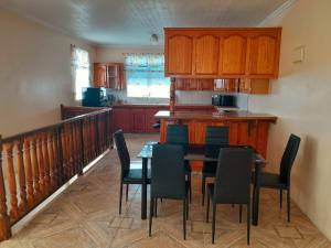 a kitchen with a table and chairs in a room at Stephen Guest House in Mahaut +6 photos