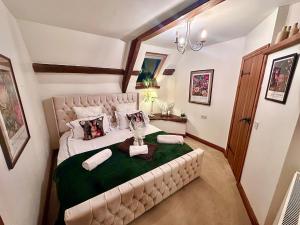 une chambre avec un grand lit avec une couverture verte dans l'établissement Luxury 4 bed former hay loft SLEEPS 6, à Usk