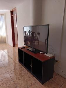 Elle comprend une télévision à écran plat installée au-dessus d'une armoire. dans l'établissement Departamento con Estacionamiento en Tacna, à Tacna