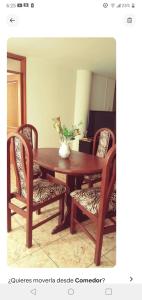 une table en bois avec des chaises et un vase. dans l'établissement Departamento con Estacionamiento en Tacna, à Tacna 6 autres photos