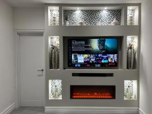 a tv in a wall with a fire place at Stylish 2 Bedroom Flat City Centre - Free Parking in Cardiff