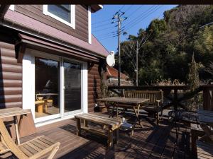 a wooden deck with a picnic table and benches at ALL SEASON RESORT No2 Torino Saezuri in Chōjamachi