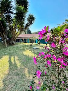 a house with pink flowers in front of a yard at Chácara NataOriBon- Ibiuna - SP in Ibiúna