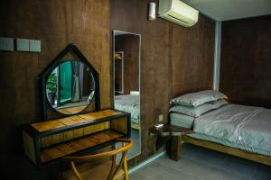 a bedroom with a mirror and a bed and a chair at Pondok Beach Shack in Tioman Island