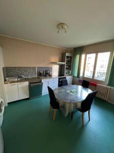 a kitchen with a table and chairs in a room at Appartement spacieux centre-ville in Mulhouse