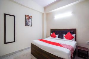 a bedroom with a large bed with red pillows at HOTEL O SILVER PALACE in New Delhi
