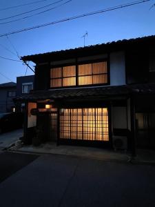 a building with two garage doors in the dark at 宿すごろく in Nagahama
