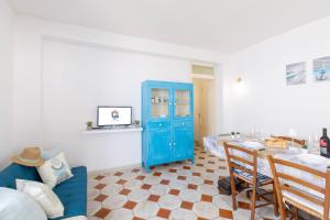 a living room with a blue cabinet and a table at La Vela bianca in Calasetta +27 photos