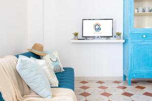 a blue couch with a hat sitting in a living room at La Vela bianca in Calasetta