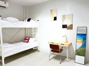 a bedroom with two bunk beds and a desk at Stay at Go Green Chiang Rai in Chiang Rai