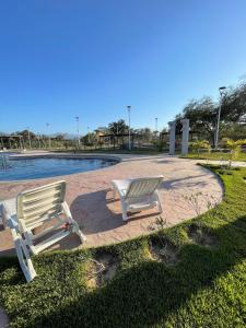 two white chairs sitting next to a pool at FW Peninsula Rental in Puerto Vallarta