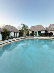 a large swimming pool in front of some houses at Hotel Kocai Izamal in Izamal