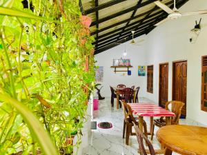 a dining room with a table and chairs and plants at Pranu House in Nilaveli +83 photos