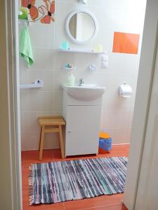 ein Badezimmer mit einem Waschbecken, einem Spiegel und einem Teppich in der Unterkunft pl.Outback in Białowieża