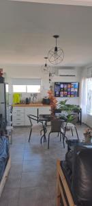 a living room with a table and chairs and a kitchen at Mini casa relajante in Balneario El Condor