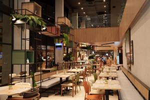 a restaurant with tables and chairs and people in the background at ibis Tangará Da Serra in Tangara da Serra