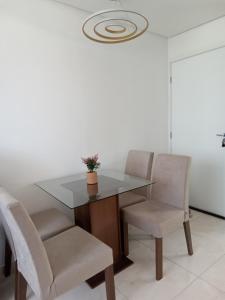 tavolo da pranzo con sedie e pianta in vaso di Apartamento porto dos mares a Salvador