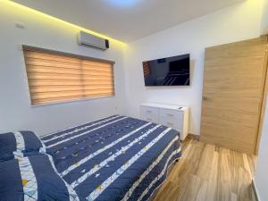 a bedroom with a bed and a window and a tv at Villa Koi con Piscina privada climatizada in Punta Cana +12 photos