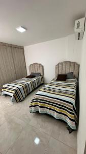 two beds sitting next to each other in a room at Casa Boutique Las Acacias in Valledupar +2 photos