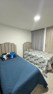 a bedroom with two beds with blue sheets at Casa Boutique Las Acacias in Valledupar