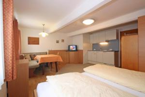 Zimmer mit 2 Betten, einer Küche und einem Tisch in der Unterkunft Appartements Schwaiger by Schladming-Appartements in Schladming + 13 Fotos