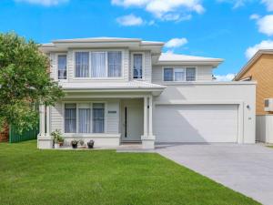 une maison blanche avec un garage dans l'établissement Kingsleys Charm at Boat Harbour, à Boat Harbour
