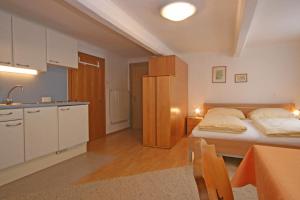um pequeno quarto com uma cama e uma cozinha em Appartements Schwaiger by Schladming-Appartements em Schladming