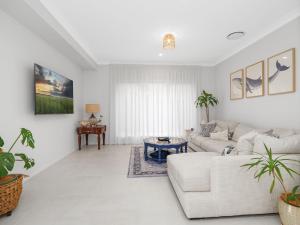 un salon blanc avec un canapé et une table dans l'établissement Kingsleys Charm at Boat Harbour, à Boat Harbour