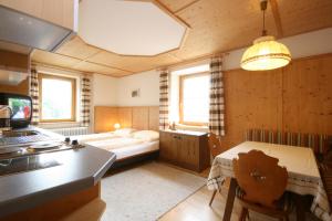 um pequeno quarto com uma cama e uma cozinha com um fogão em Appartements Schwaiger by Schladming-Appartements em Schladming