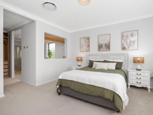 une chambre blanche avec un lit et un miroir dans l'établissement Kingsleys Charm at Boat Harbour, à Boat Harbour