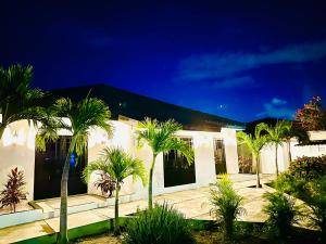 a white building with palm trees in front of it at Eagle Stays Aruba-NEW Charming One Bedroom Retreat, Cozy & Close to Eagle Beach! in Oranjestad