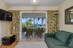 a living room with a couch and a table with chairs at Coopers Perch - Coopers Beach Couples Retreat in Coopers Beach