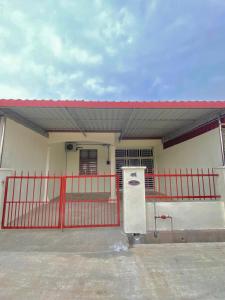 a small house with a red fence and a gate at Homestay Selesa Taman Lembah Bujang in Bedung