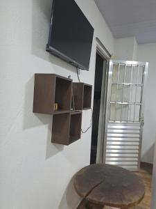 贝洛奥里藏特Condomínio da Mercês的房间里有一张桌子和一台挂在墙上的电视